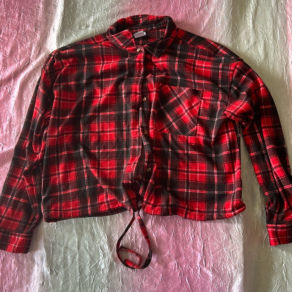 This is a red and black plaid patterned long sleeve. The shirt is also cropped